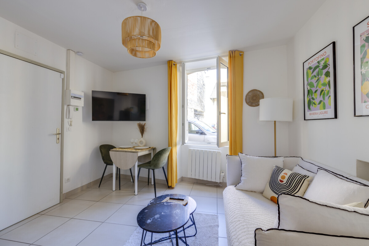 Salon lumineux appartement Herriot 5 Brive – Canapé confortable, TV murale et coin repas