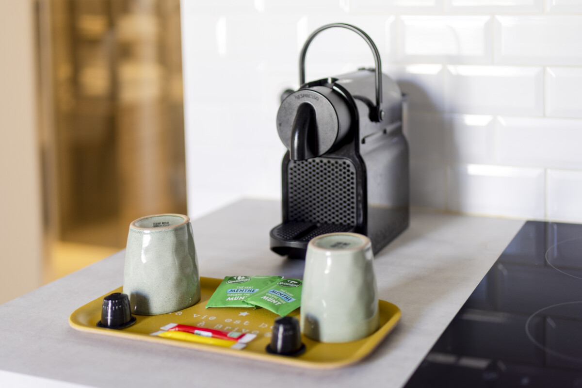 Machine Nespresso Herriot 5 Brive – Plateau d’accueil avec tasses, capsules et sachets de thé en cuisine moderne