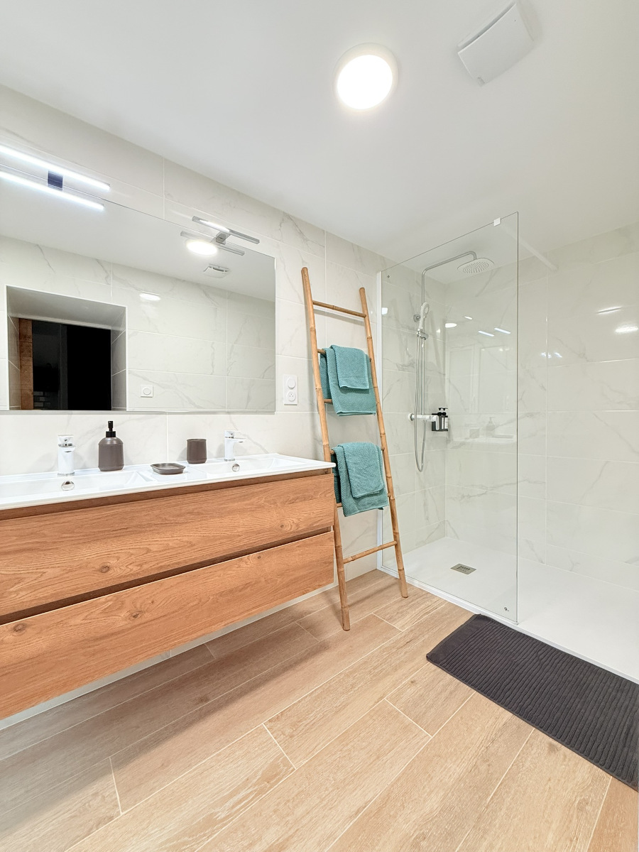 Salle de bain moderne avec douche à l’italienne, meuble vasque en bois et finitions haut de gamme – Appart’Cosy