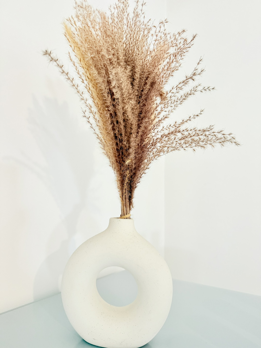 Détail décoration naturelle avec vase en céramique et fleurs séchées dans appartement Appart’Cosy à Brive-la-Gaillarde